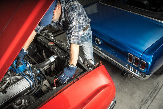 Mechanic fixing a classic car parked with its hood open